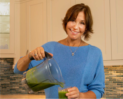Karen Reynolds pouring a green smoothie